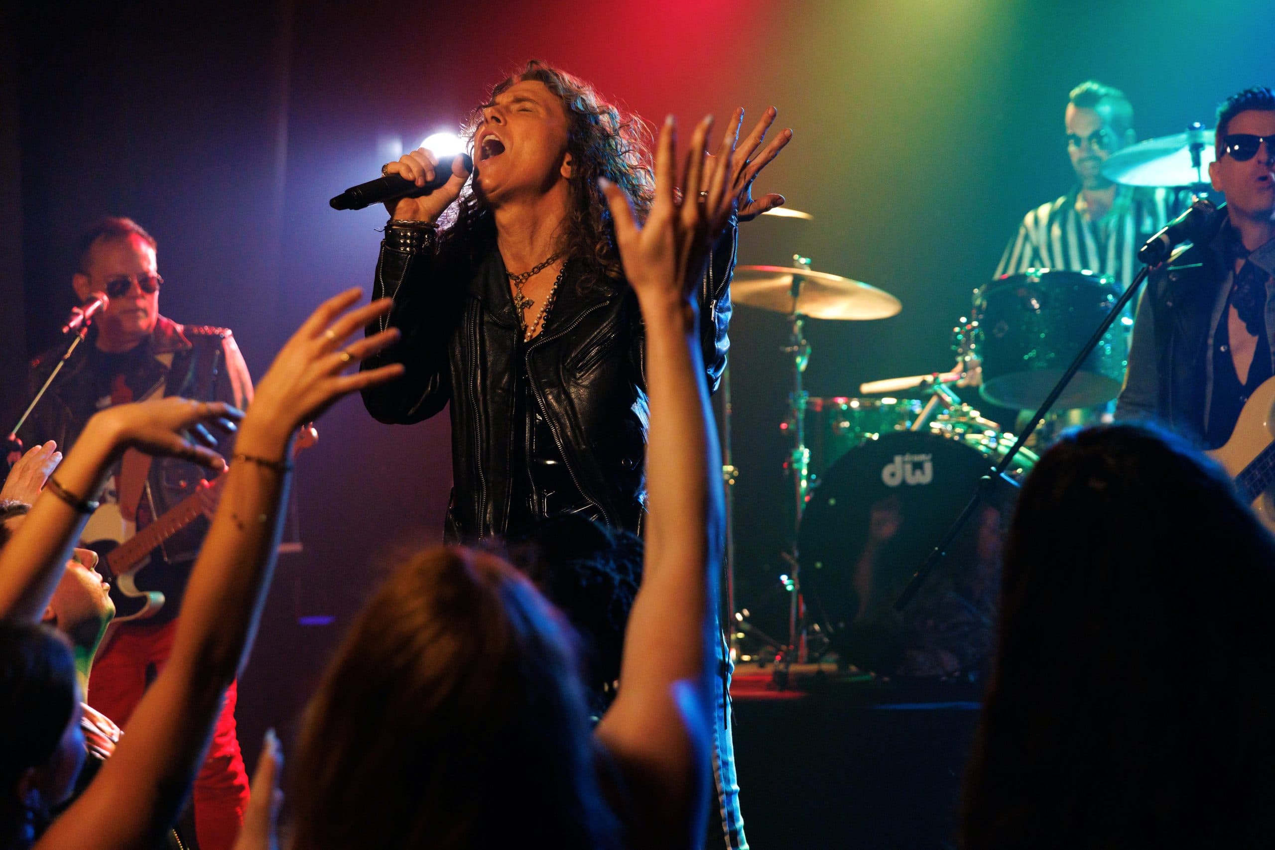 The singer with arms raised in front of the band