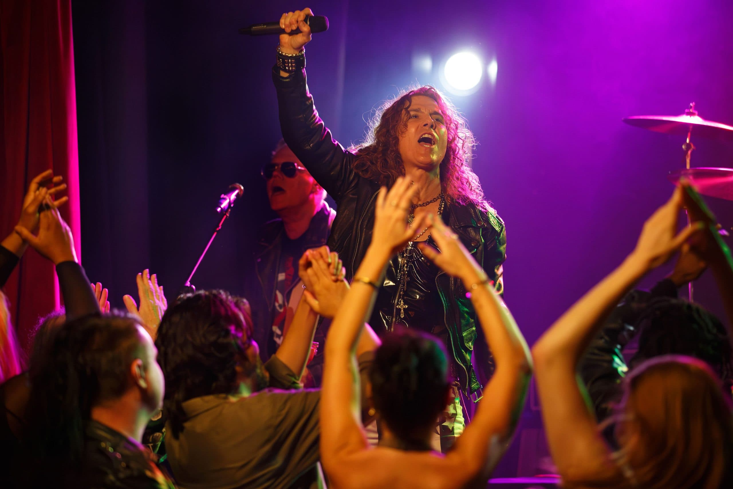 The band performing an encore under pink and blue stage light