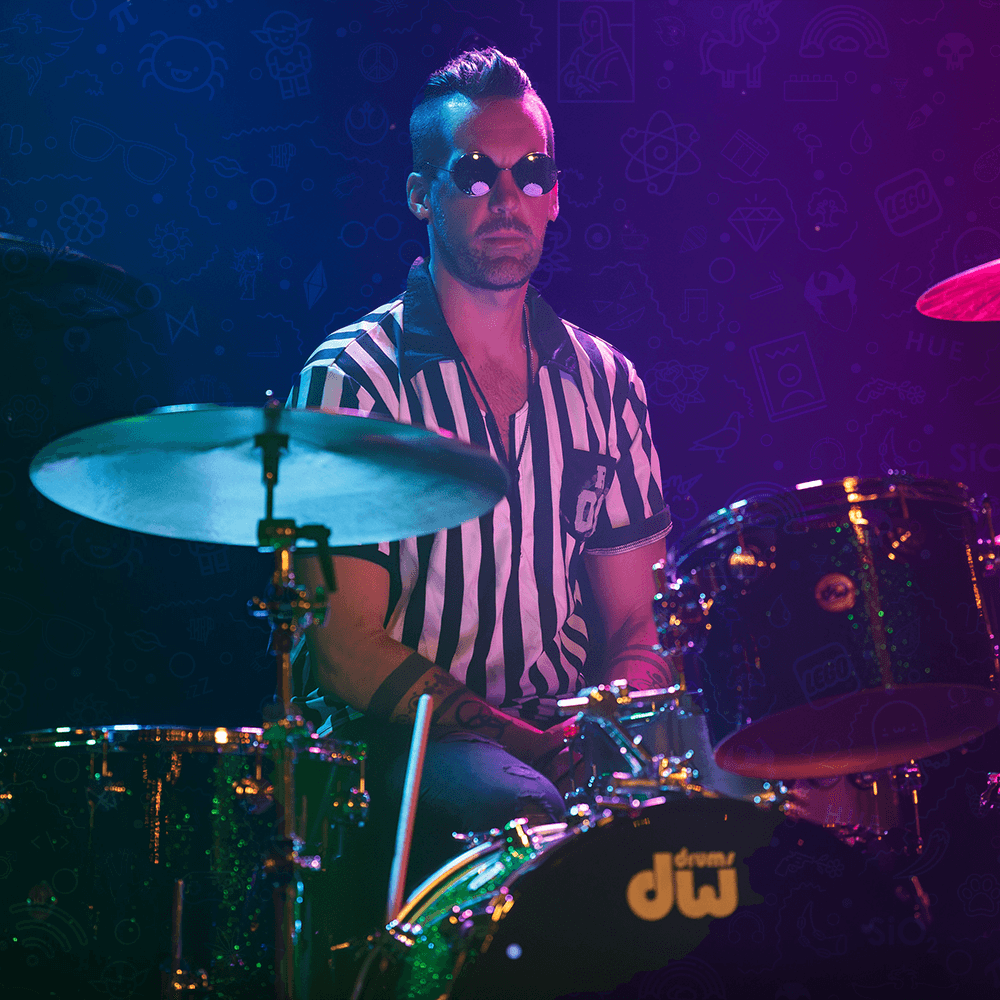 Zack St. John behind the drum kit in a striped shirt